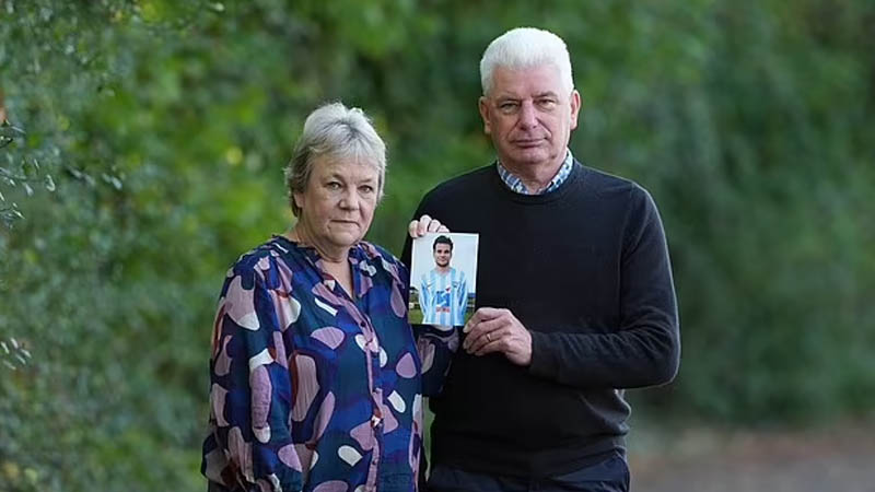 Caroline and Bob Schilt holding a picture their son